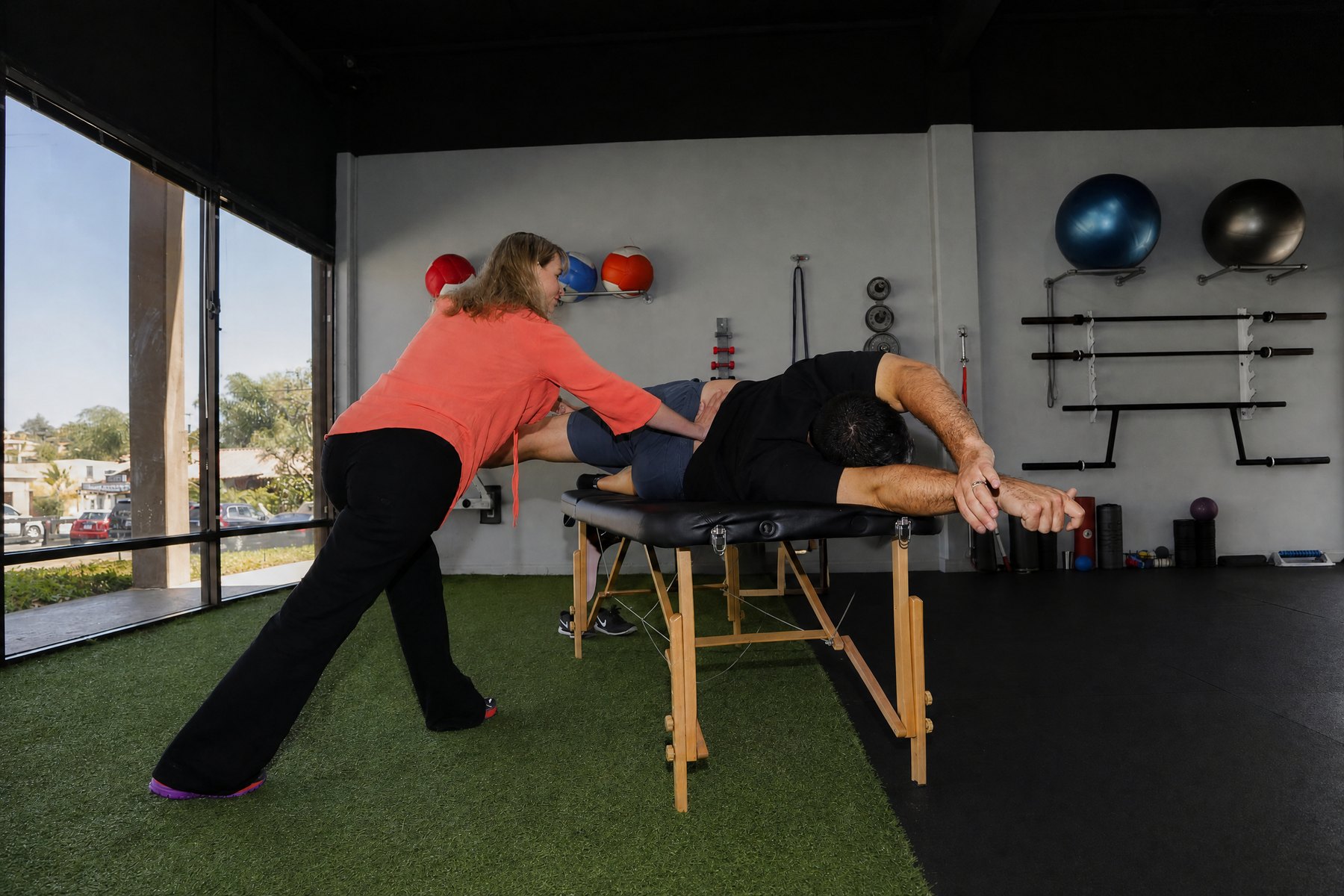 Practitioner guiding a client through a full-body movement and fascial stretching position.