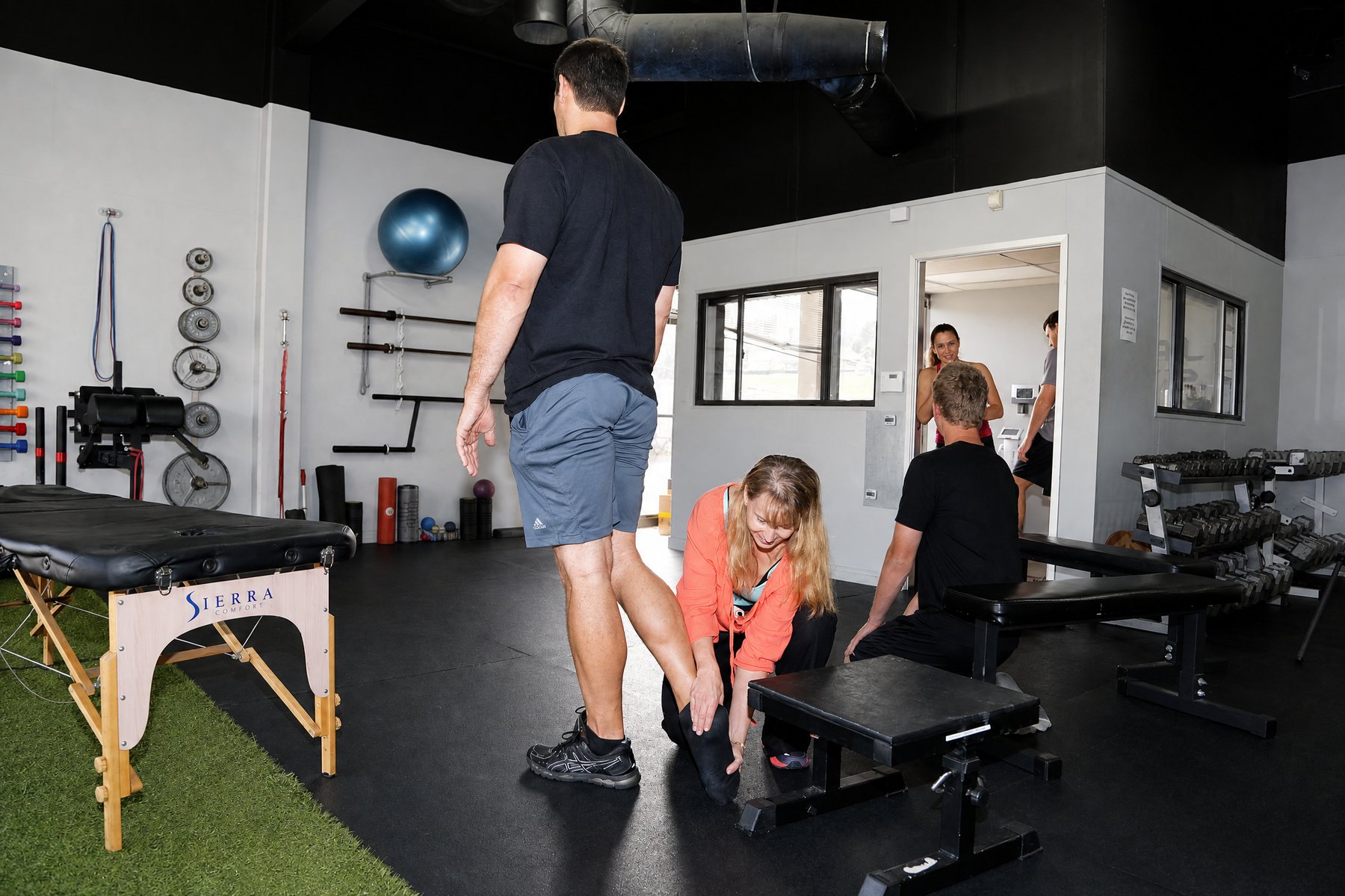 Instructor guiding a participant through a calf and lower-body movement technique in a performance studio.
