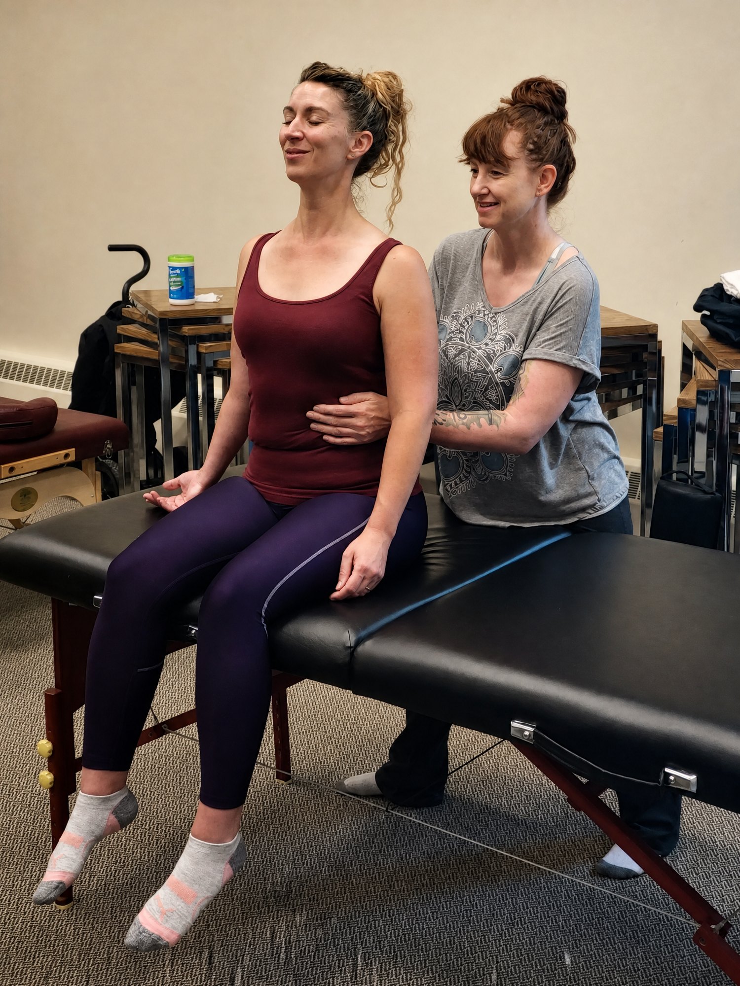 Upper-Body Movement Work Practitioner supporting a seated client during upper-body movement work.